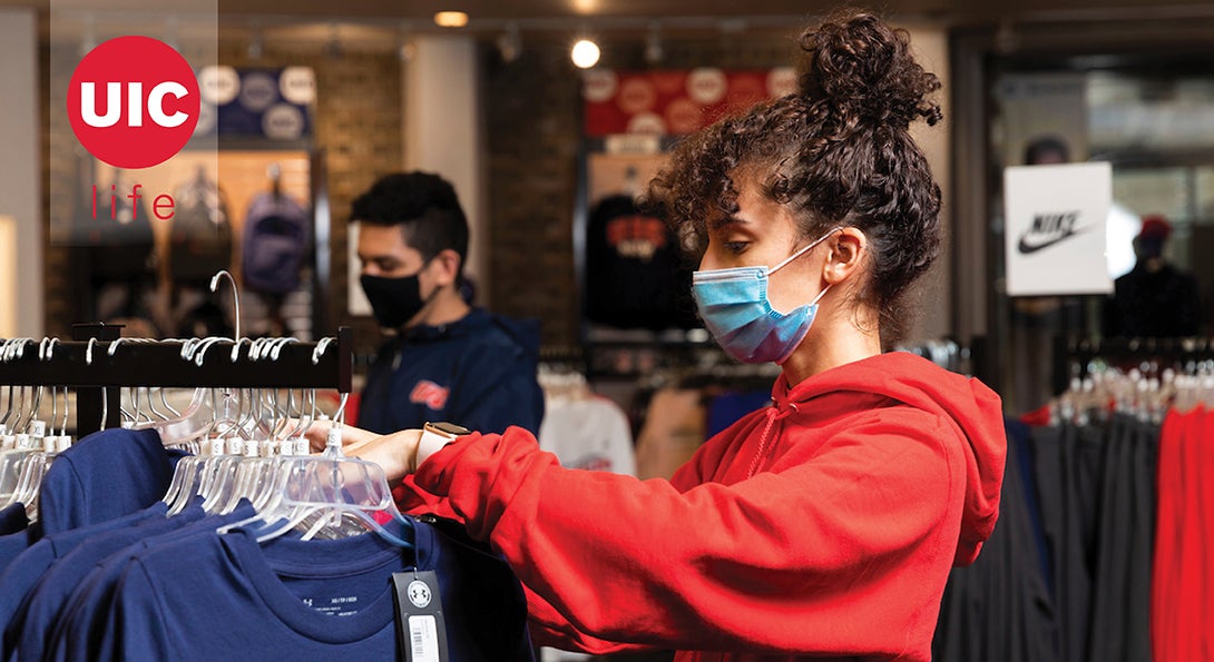 Female student in red hoodie shopping at the UIC Bookstore.