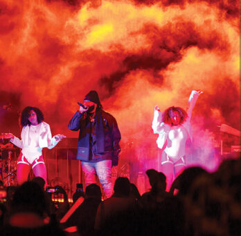 college crowds enjoys live concert with smoke and orange lighting
                  