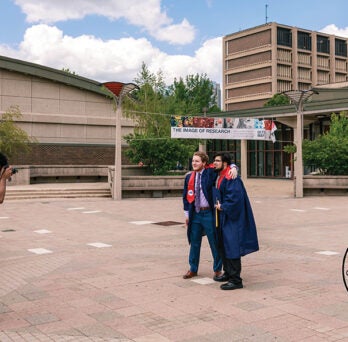 A photographer takes graduation photos at the Quad at UIC.
                  