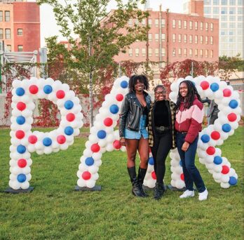 UIC students in front of large SPARK balloons, City of Chicago in background
                  