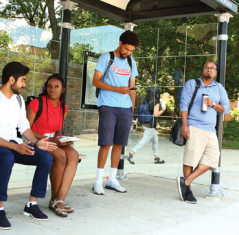 Four UIC commuter students at a bus stop
                  