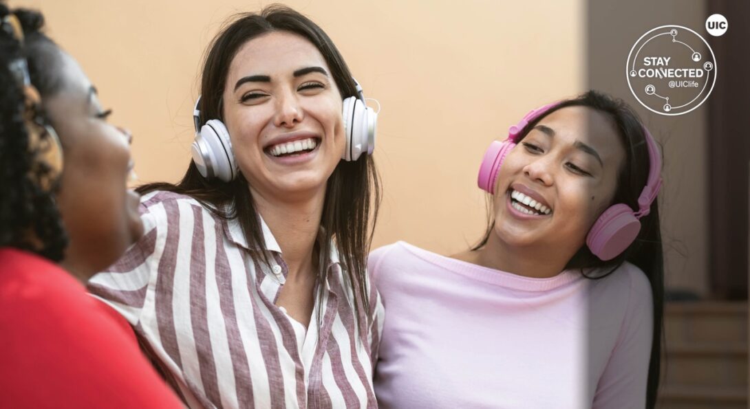 three female students enjoying music through headphones